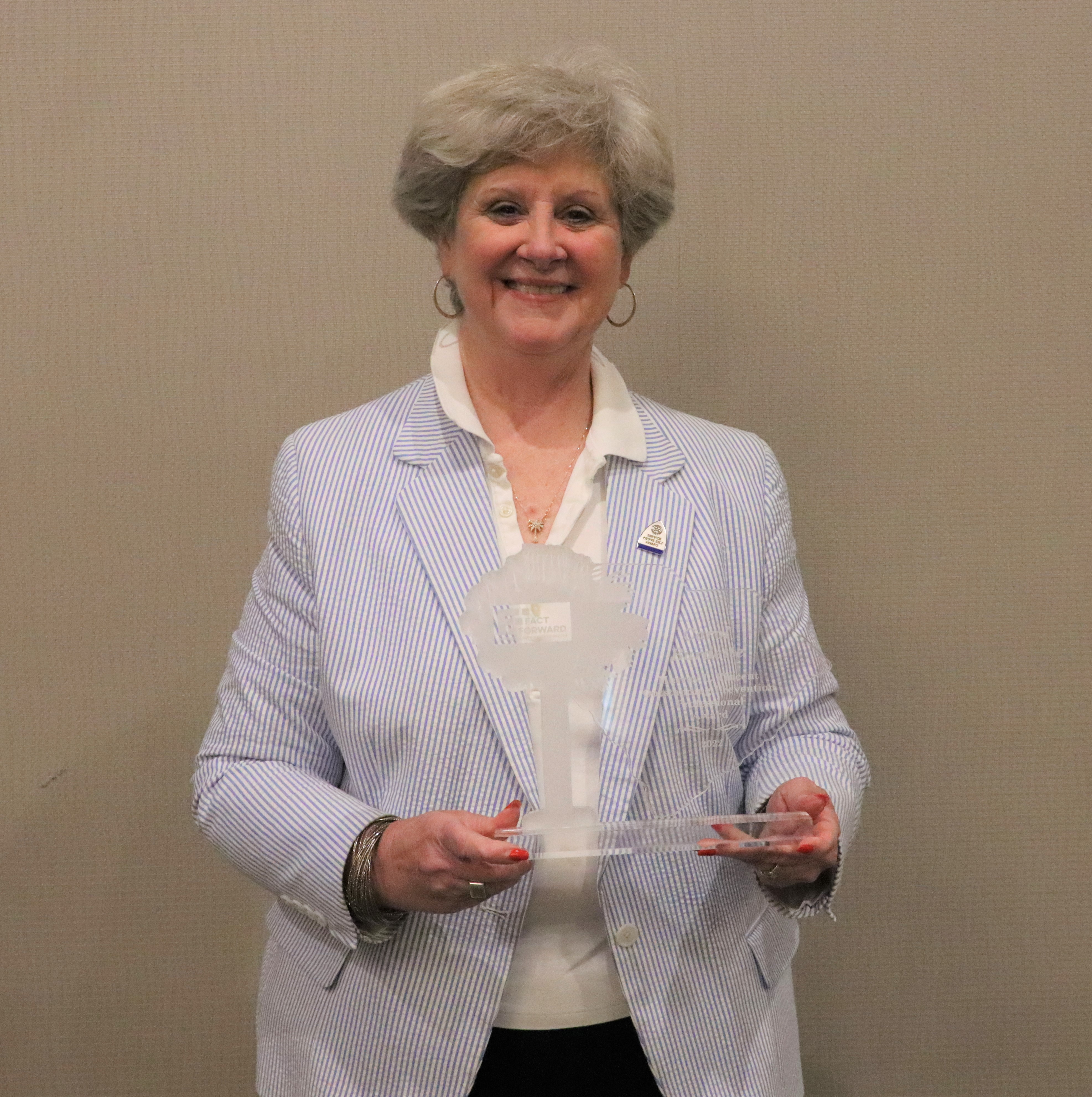 Carol Burdette holding clear South Carolina shaped award